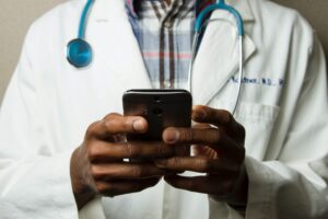 african doctor holding his phone